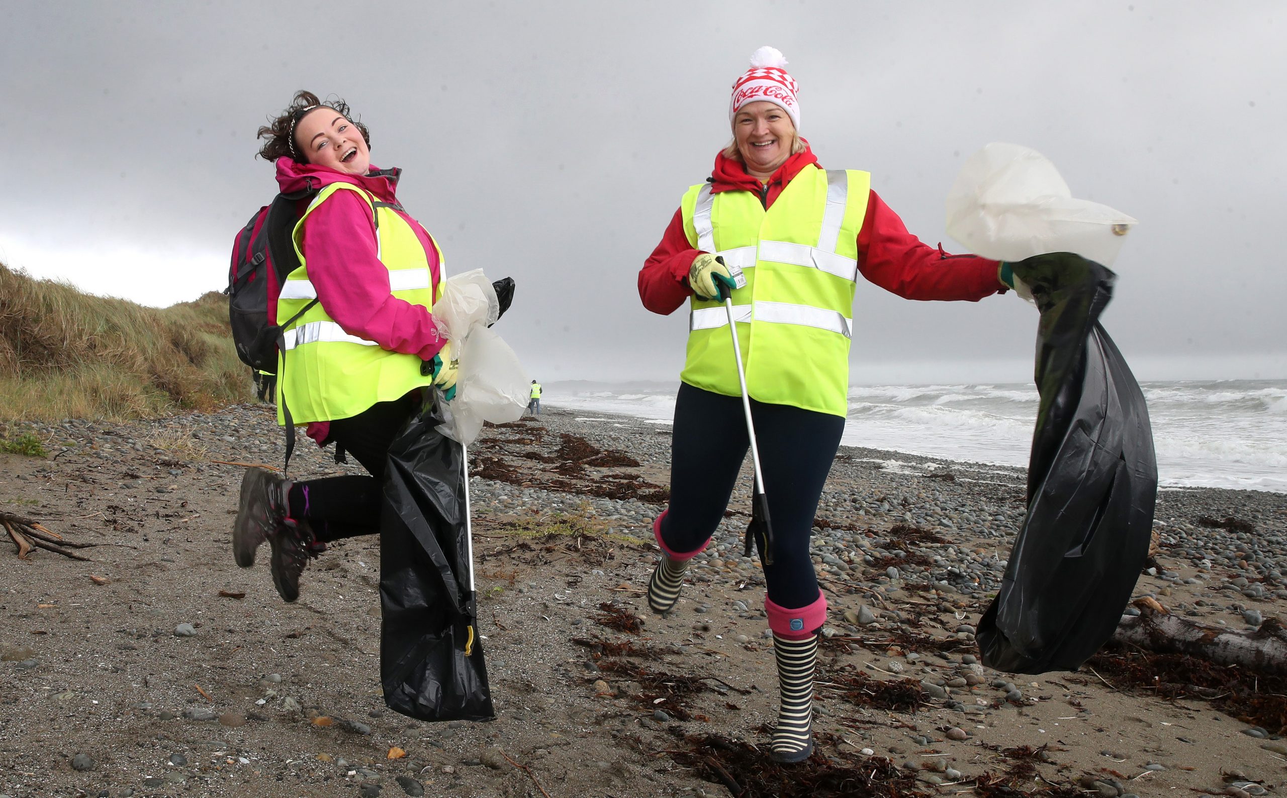 Two employer supported volunteers from Coca Cola on Murlough Beach with litter pickers and black bags